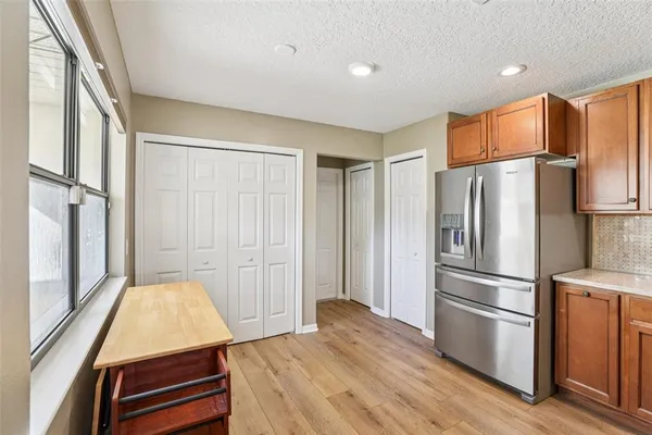a kitchen with stainless steel appliances a refrigerator and wooden floor