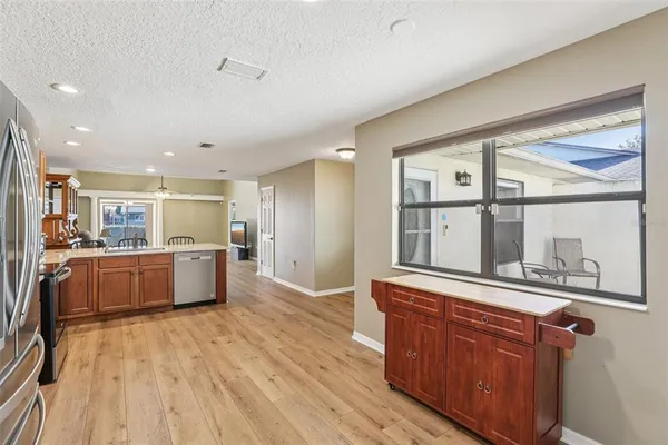 a large kitchen with stainless steel appliances wooden floors and wooden cabinets