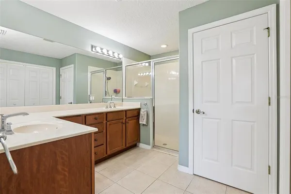 a bathroom with a sink vanity granite tub and a mirror