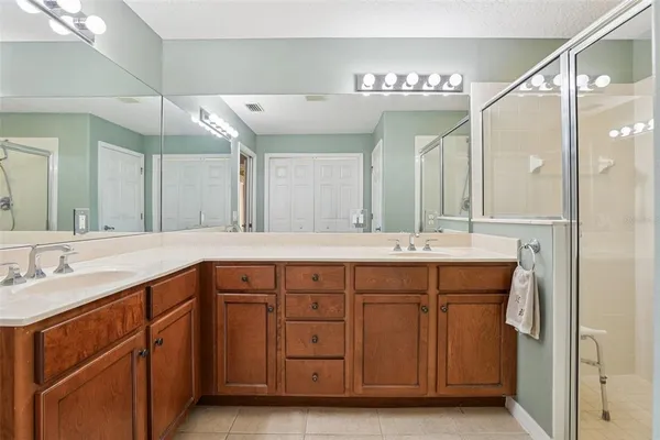 a spacious bathroom with a granite countertop sink a mirror and a shower