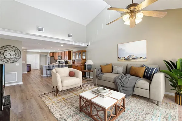 a living room with furniture a chandelier and a wooden floor
