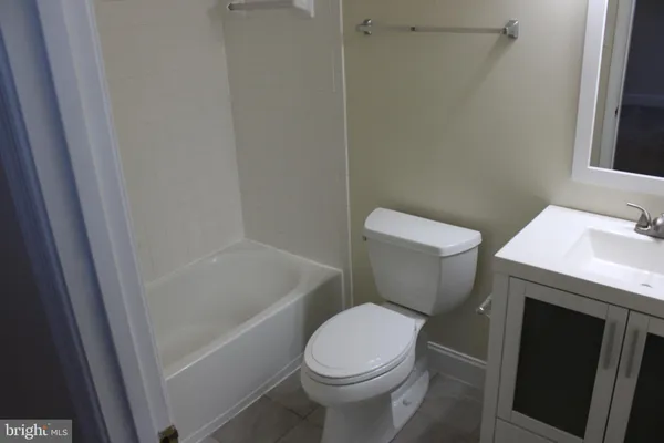 a white toilet sitting next to a bath tub