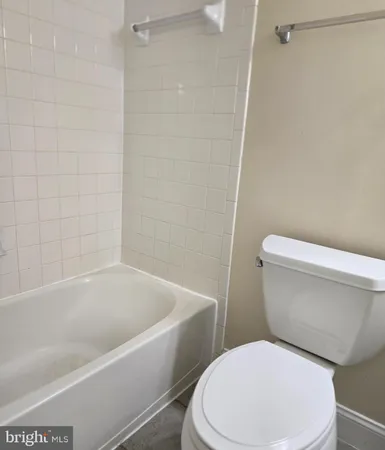 a white toilet and tub sitting next to a bathroom sink