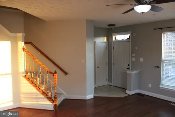 a view of an empty room with wooden floor and windows