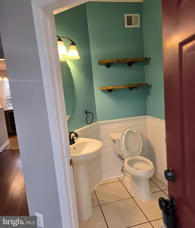 a bathroom with a sink a toilet and a mirror