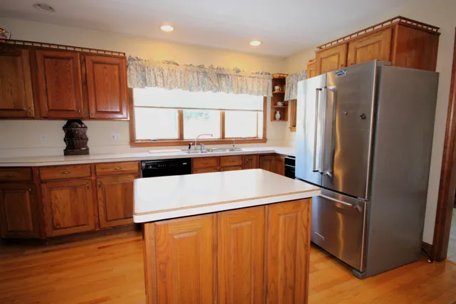 a kitchen with stainless steel appliances a refrigerator and wooden cabinets
