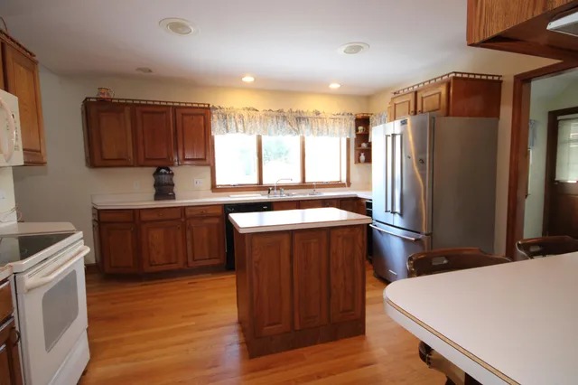 a kitchen with a refrigerator sink and wooden cabinets