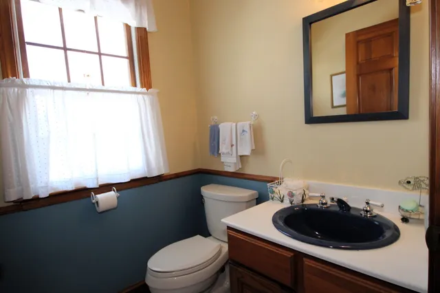 a bathroom with a sink a toilet and a window