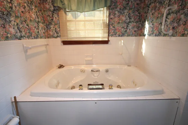 a bath tub sitting in a bathroom next to a window
