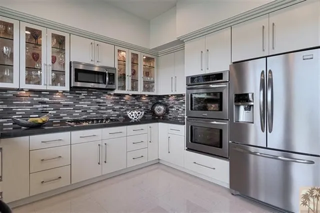a kitchen with white cabinets stainless steel appliances and a sink