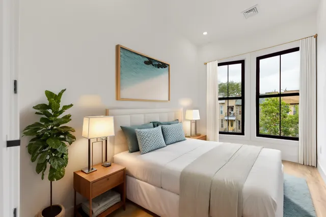 a bedroom with a large bed and a potted plant