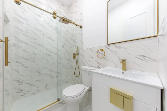 a bathroom with a sink a toilet and shower