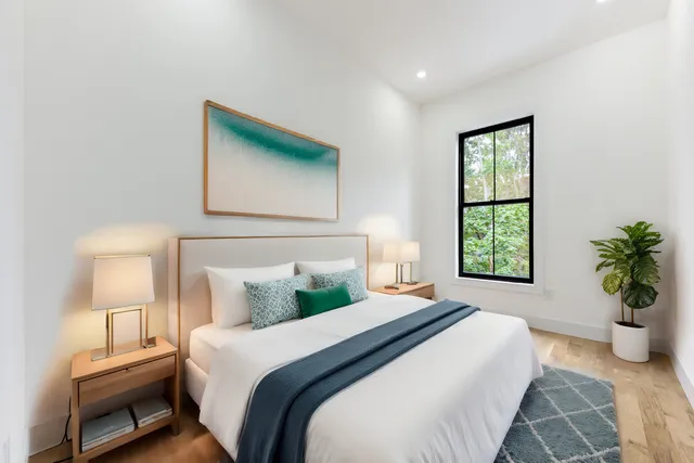 a bedroom with a bed and a potted plant