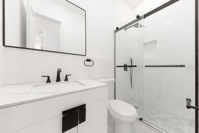 a bathroom with a sink toilet vanity and shower