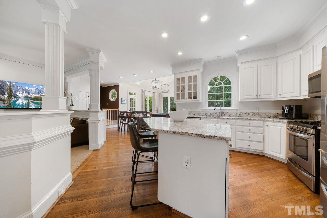5533 Overleaf Court Raleigh, NC 27615 - Photo 8 of 32 a kitchen with stainless steel appliances kitchen island granite countertop counter space a sink and cabinets