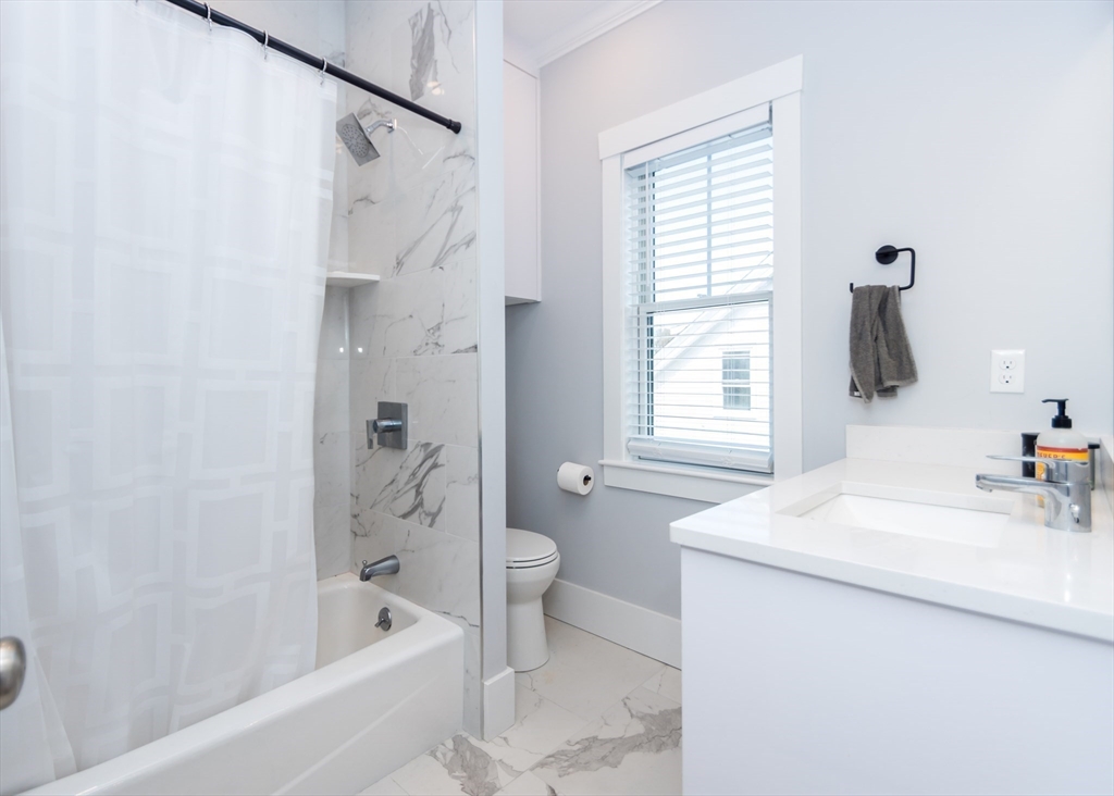 29 Cherry Street, Unit 2 Waltham, MA 02453 - Photo 14 of 18 a bathroom with a sink a toilet and a bathtub