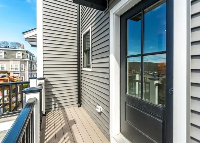 a view of a balcony with wooden floor and iron stairs