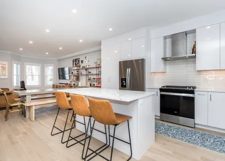 a kitchen with stainless steel appliances kitchen island granite countertop a refrigerator and a stove top oven