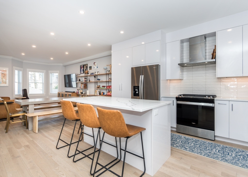 29 Cherry Street, Unit 2 Waltham, MA 02453 - Photo 2 of 18 a kitchen with stainless steel appliances kitchen island granite countertop a refrigerator and a stove top oven