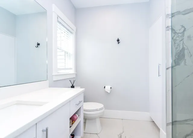 a bathroom with a sink a toilet and window