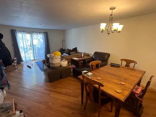 a view of a dining room with furniture a chandelier and wooden floor