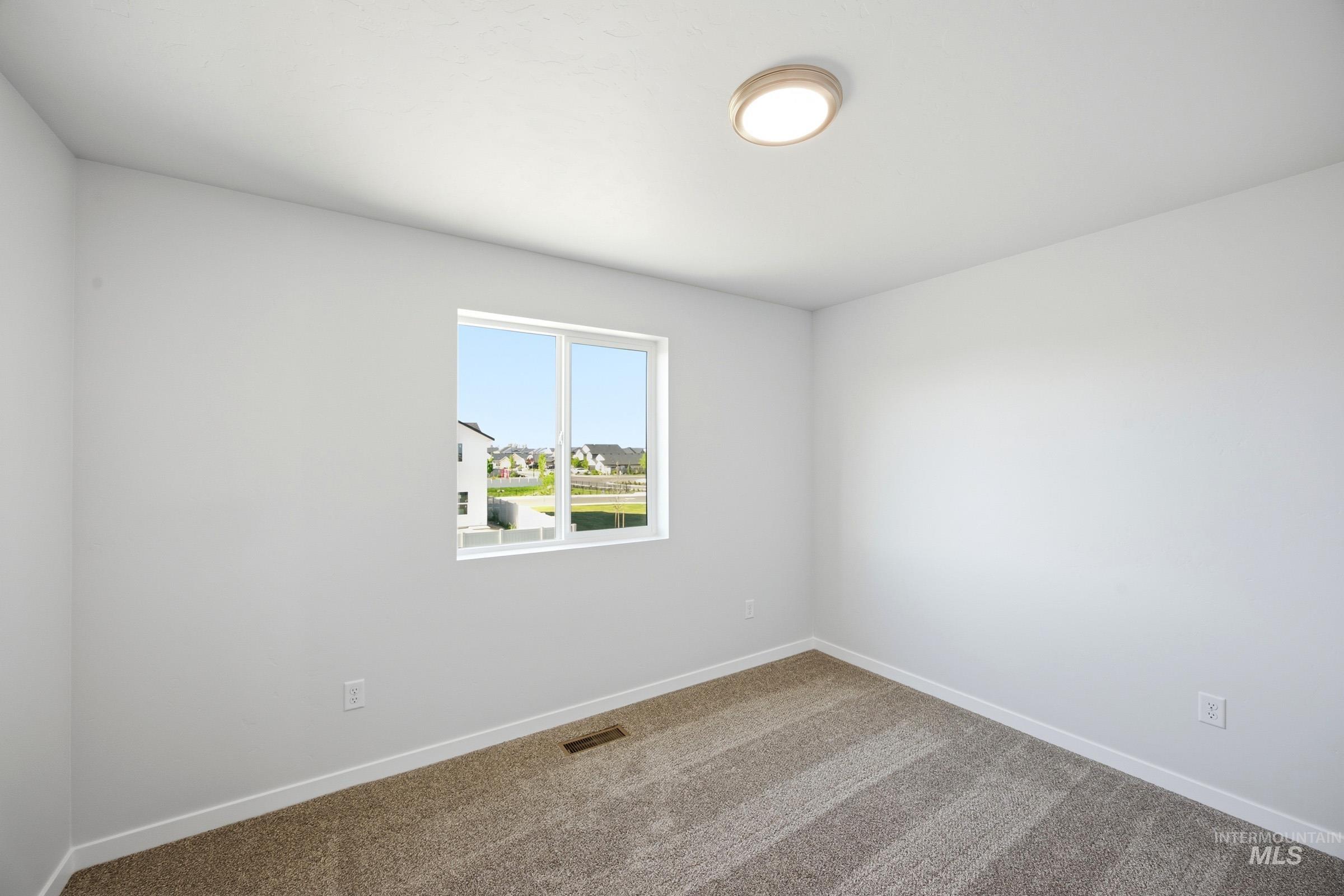 16211 Andes Avenue Caldwell, ID 83607 - Photo 13 of 22 Neutral tone painted walls, light-colored carpet flooring, recessed window, and flush mount ceiling light fixture
