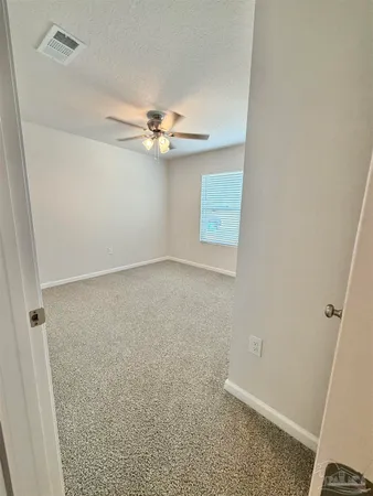 an empty room with a ceiling fan and a window