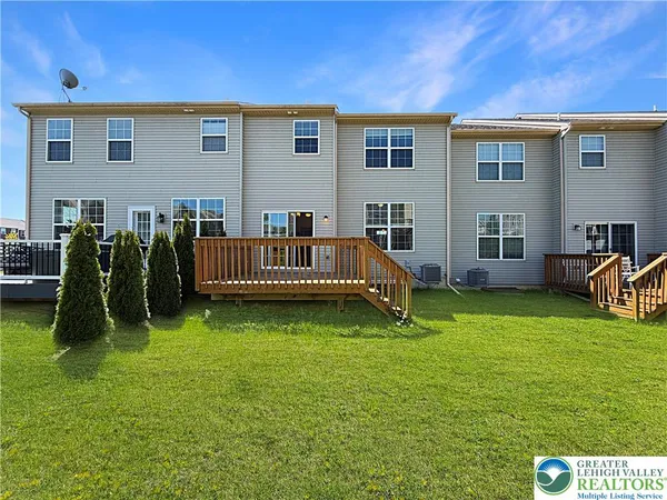 a view of backyard with deck and a patio