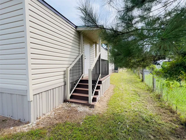 a view of a yard with plants and wooden fence