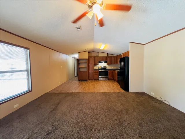 a view of empty room with a kitchen and fan