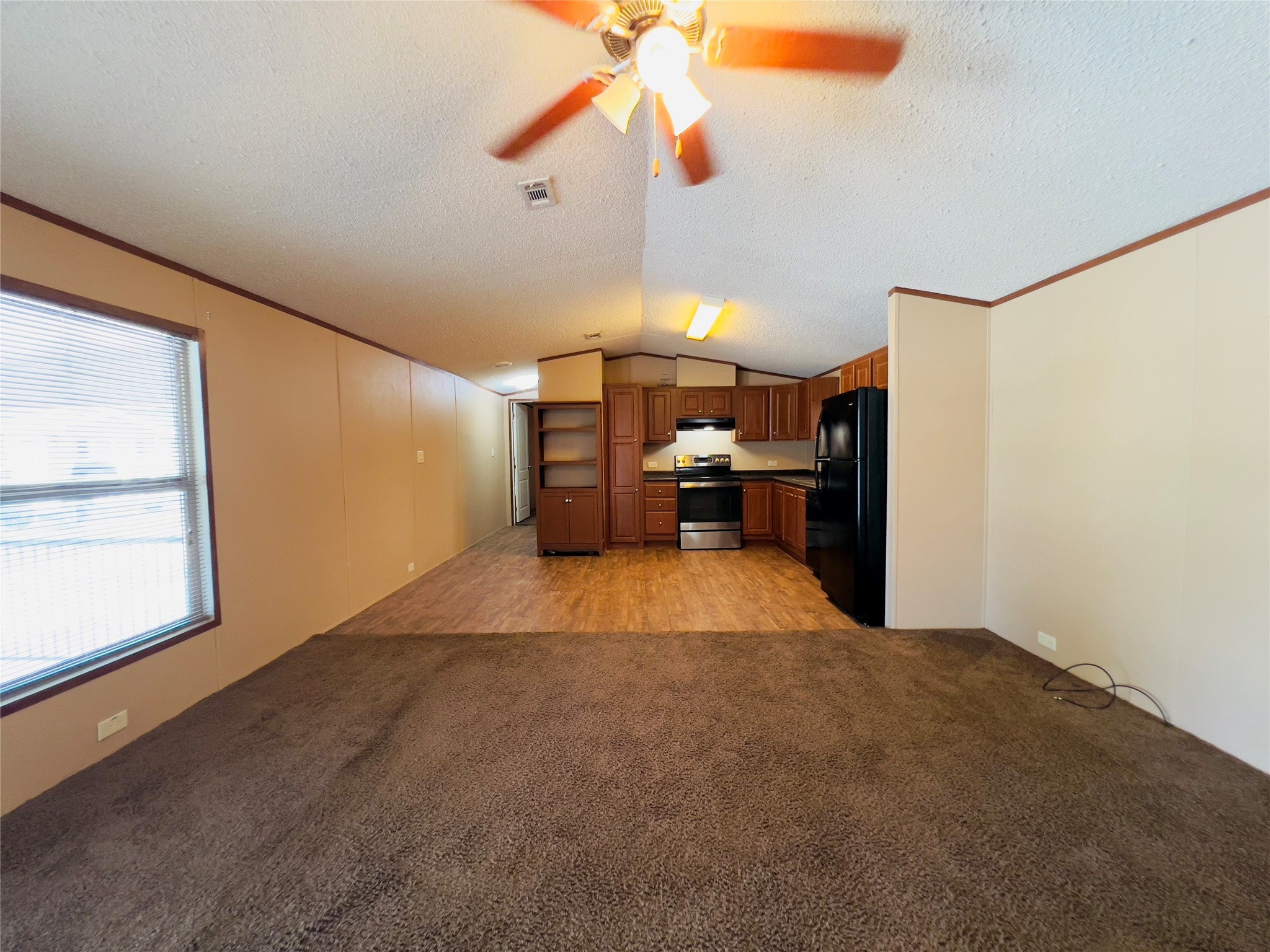788 County Road 3479 J Cleveland, TX 77327 - Photo 6 of 22 a view of empty room with a kitchen and fan