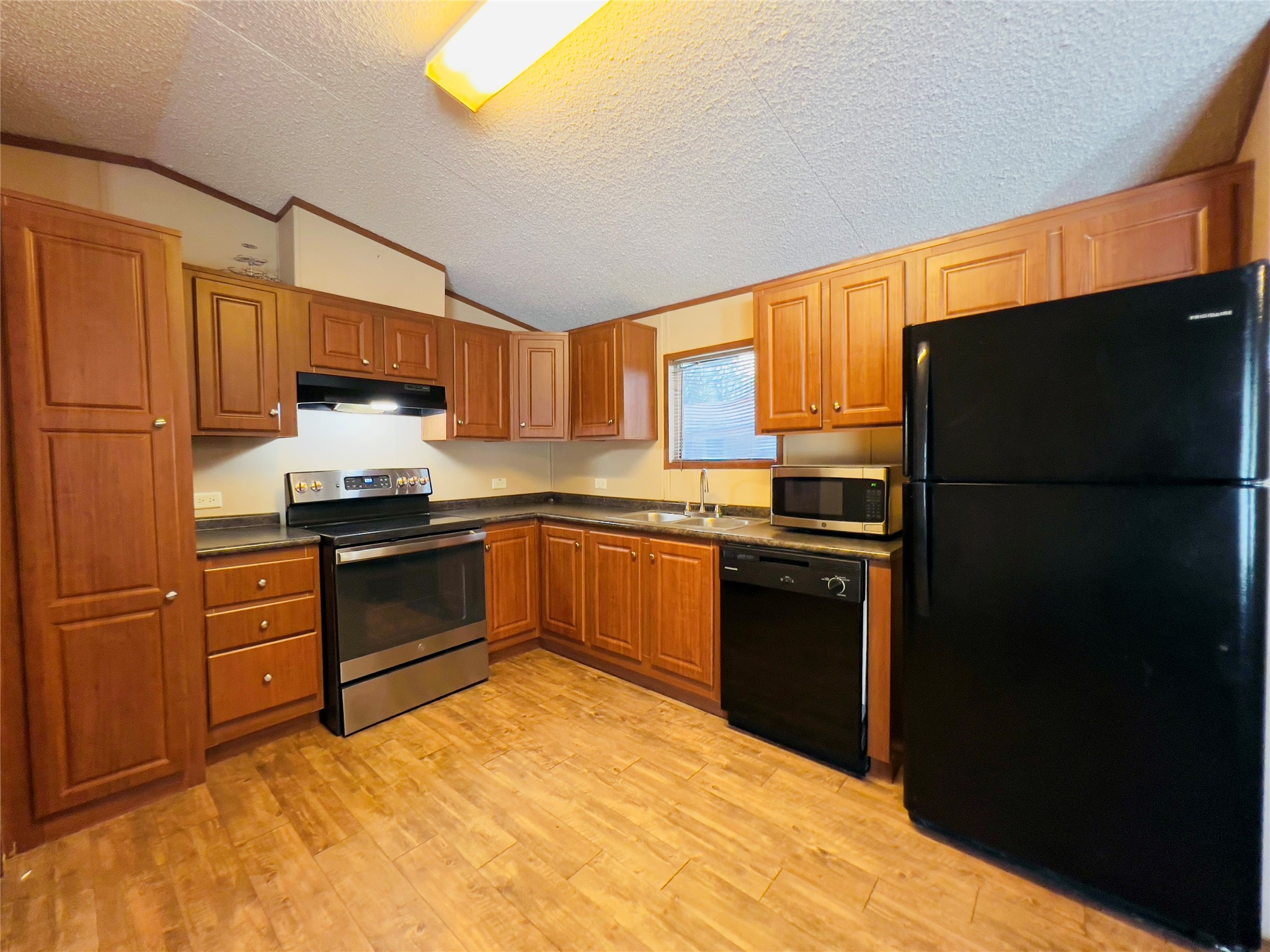 788 County Road 3479 J Cleveland, TX 77327 - Photo 8 of 22 a kitchen with a refrigerator stove and sink