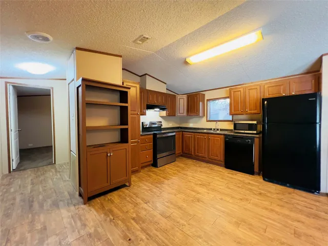 a kitchen with granite countertop stainless steel appliances and refrigerator