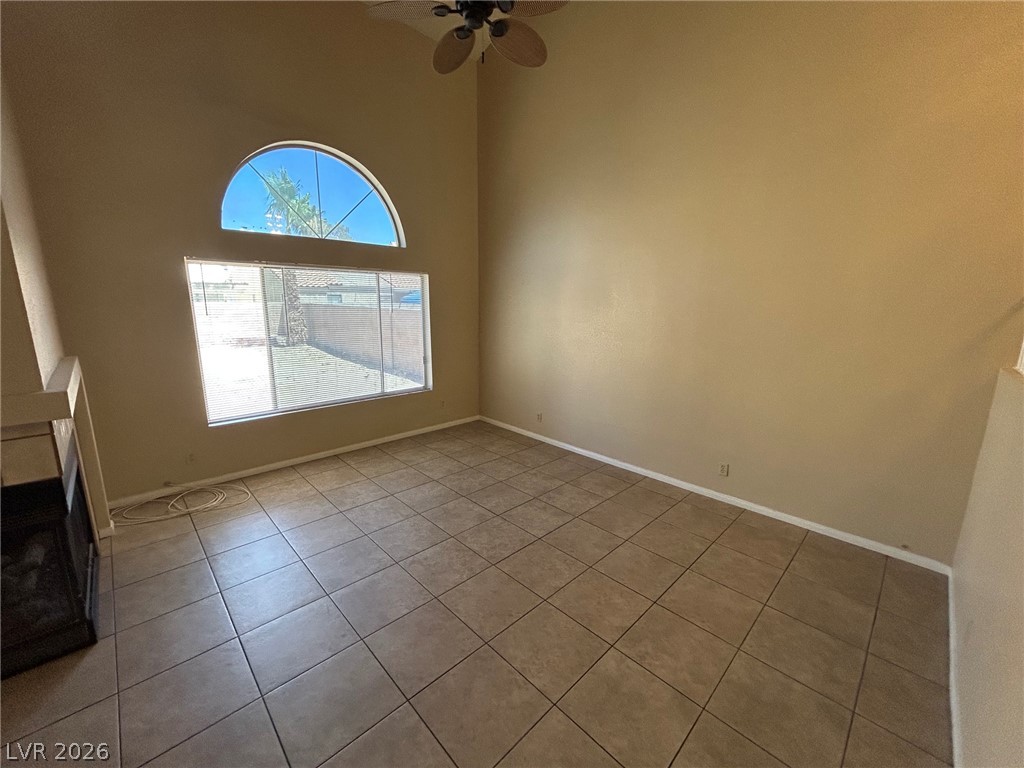 2806 Rungsted Street Las Vegas, NV 89142 - Photo 4 of 18 A living area features soaring ceilings, a striking arched window, and durable tile flooring.