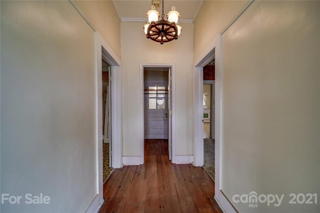 621 Graham Street Albemarle, NC 28001 - Photo 5 of 24 a view of a hallway with wooden floor and a chandelier