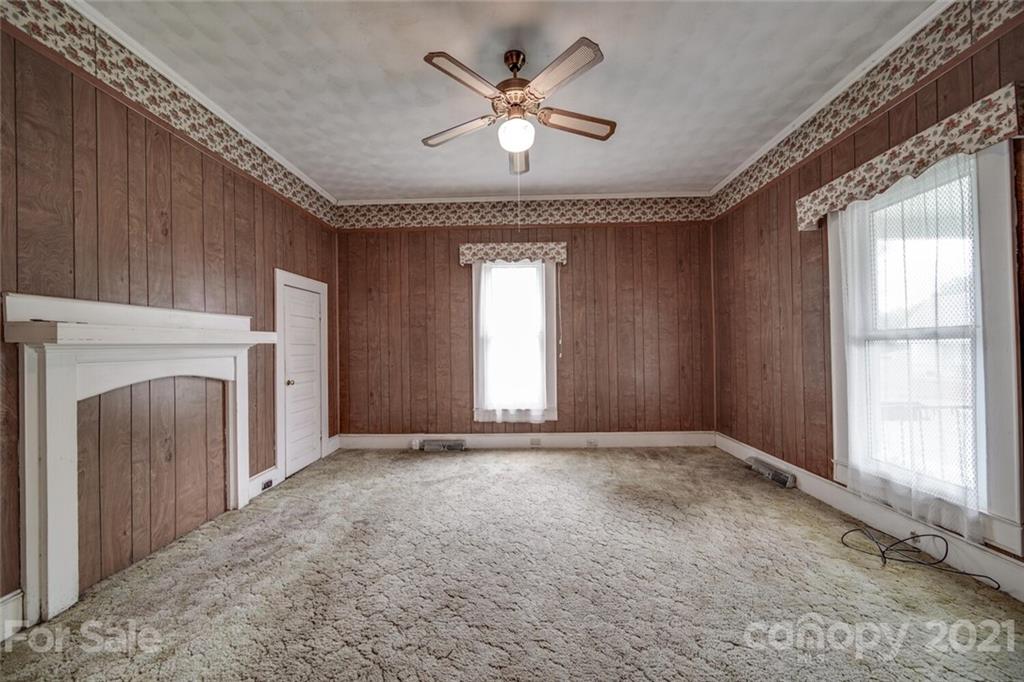 621 Graham Street Albemarle, NC 28001 - Photo 7 of 24 a view of an empty room with a fireplace and a ceiling fan