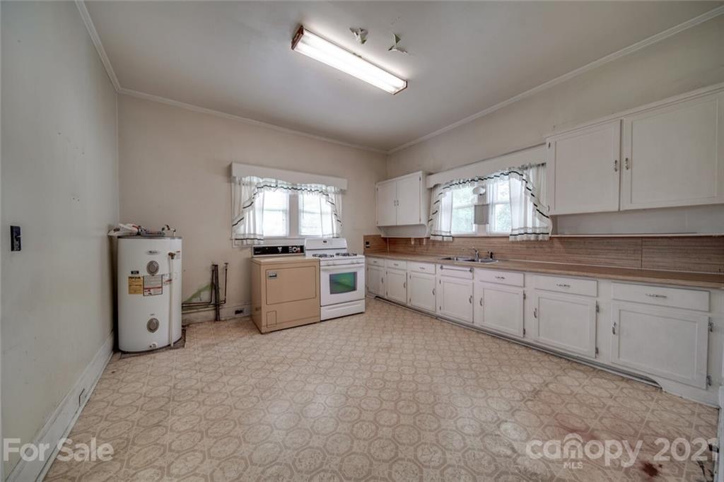 621 Graham Street Albemarle, NC 28001 - Photo 10 of 24 a large kitchen with granite countertop a stove top oven a sink a window and cabinets