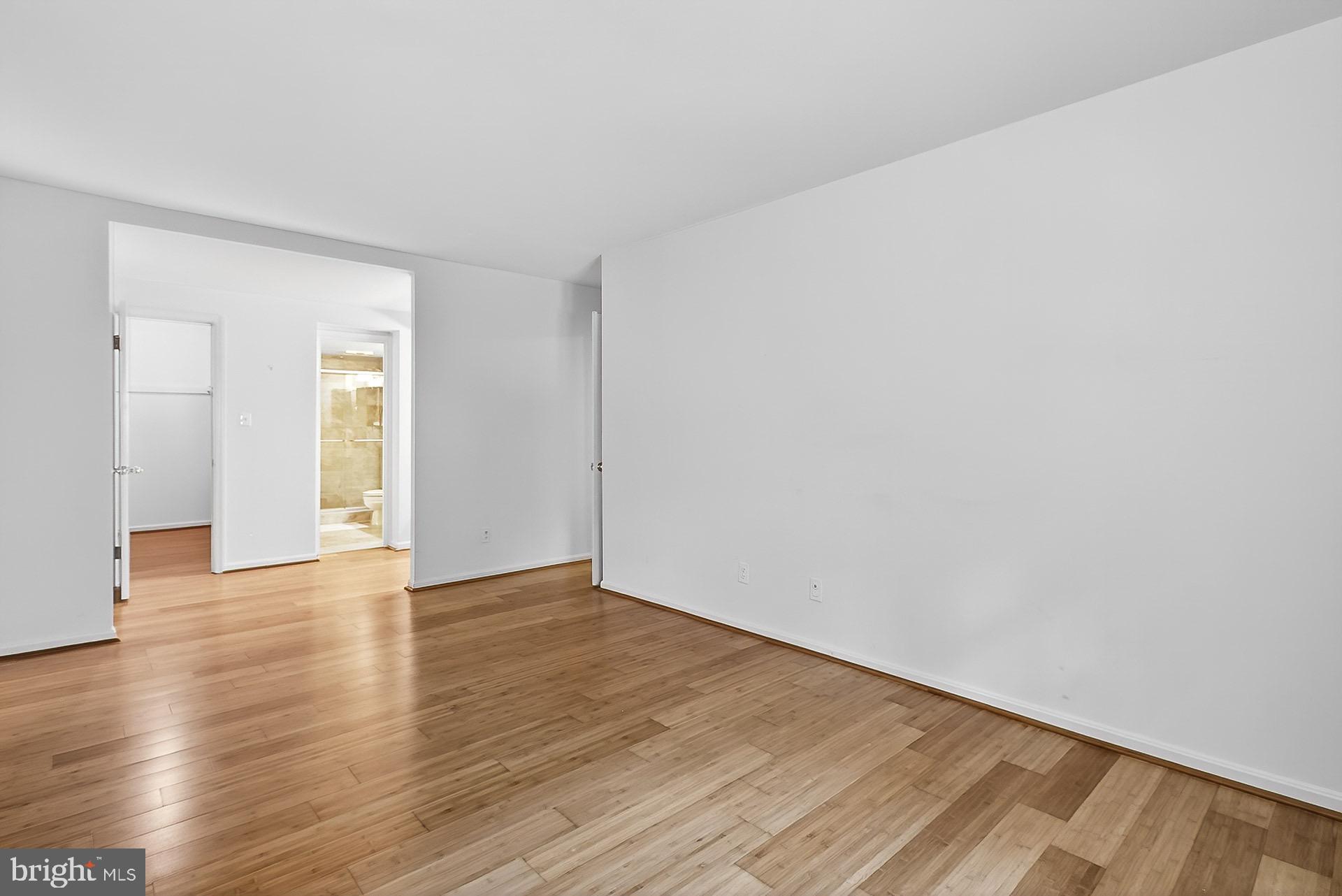 5920 Cove Landing Road, Unit 102 Burke, VA 22015 - Photo 11 of 45 a view of an empty room with wooden floor and a window