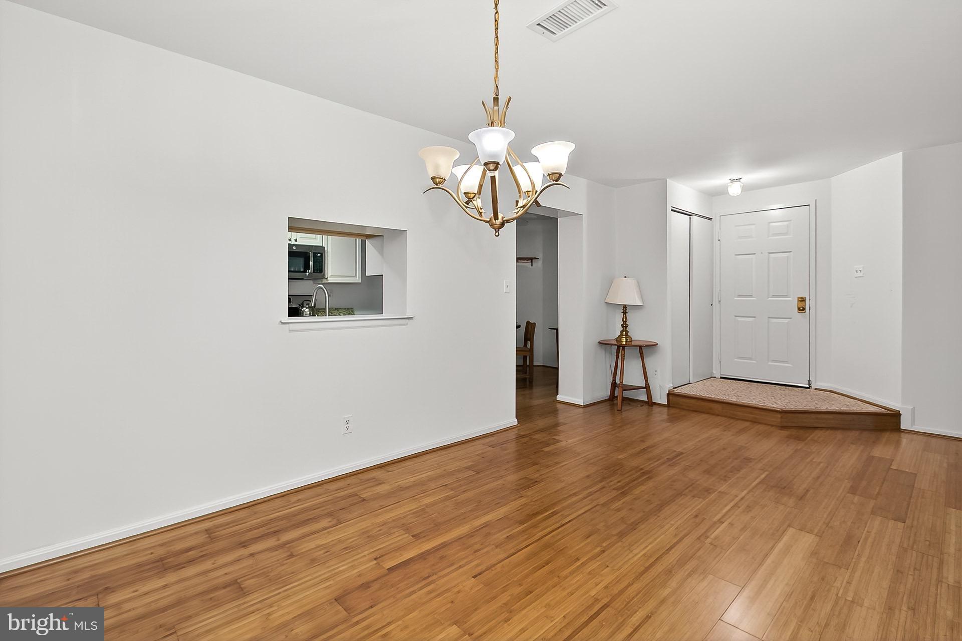 5920 Cove Landing Road, Unit 102 Burke, VA 22015 - Photo 16 of 45 a view of an empty room with wooden floor and a window