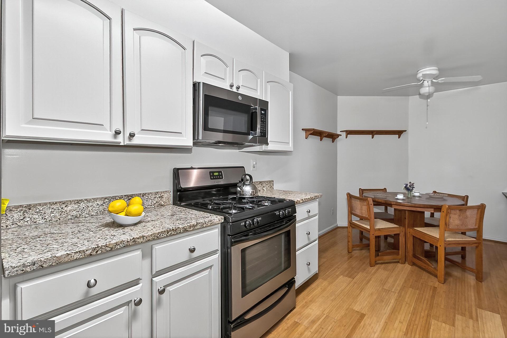 5920 Cove Landing Road, Unit 102 Burke, VA 22015 - Photo 3 of 45 a kitchen with stainless steel appliances granite countertop a stove a sink and a microwave