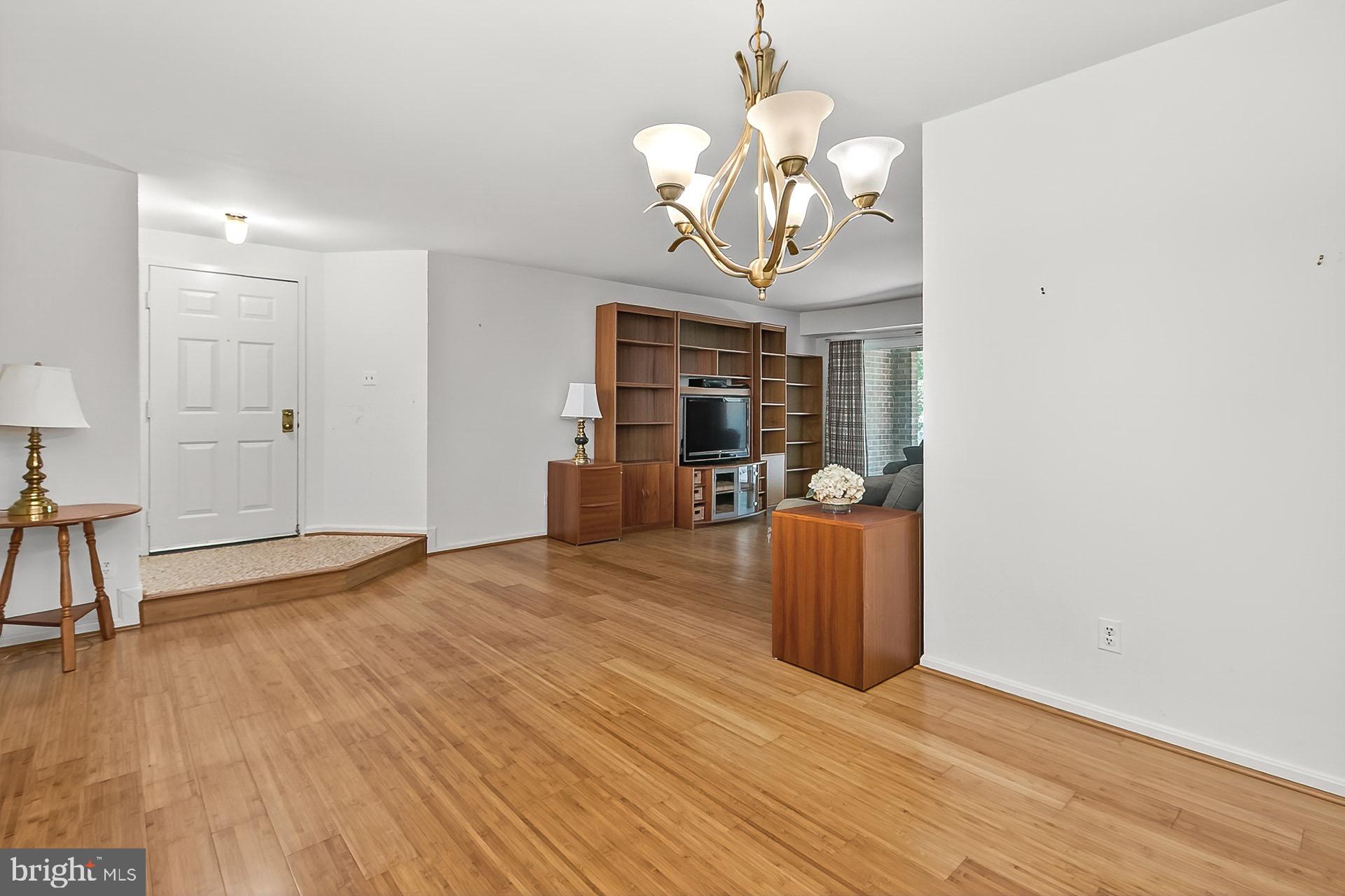 5920 Cove Landing Road, Unit 102 Burke, VA 22015 - Photo 6 of 45 a view of a room with wooden floor and chandelier