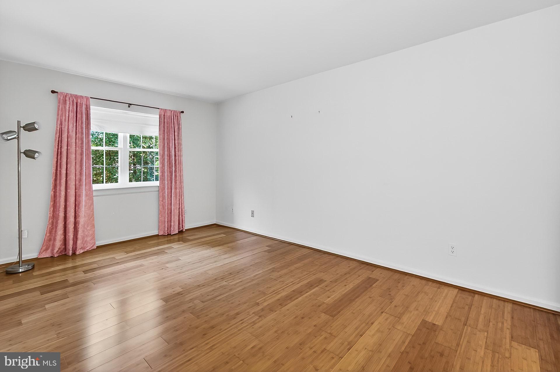 5920 Cove Landing Road, Unit 102 Burke, VA 22015 - Photo 7 of 45 a view of an empty room with wooden floor and a window