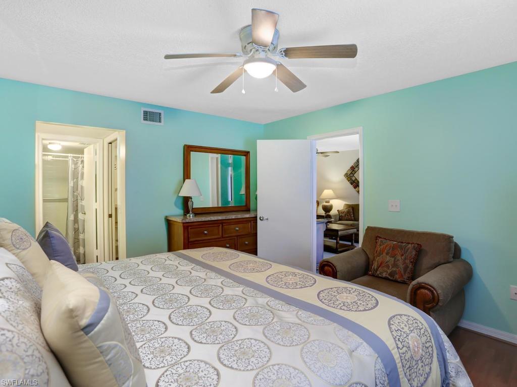 5675 Whitaker Road, Unit B102 Naples, FL 34112 - Photo 17 of 22 a bedroom with a bed and a chandelier