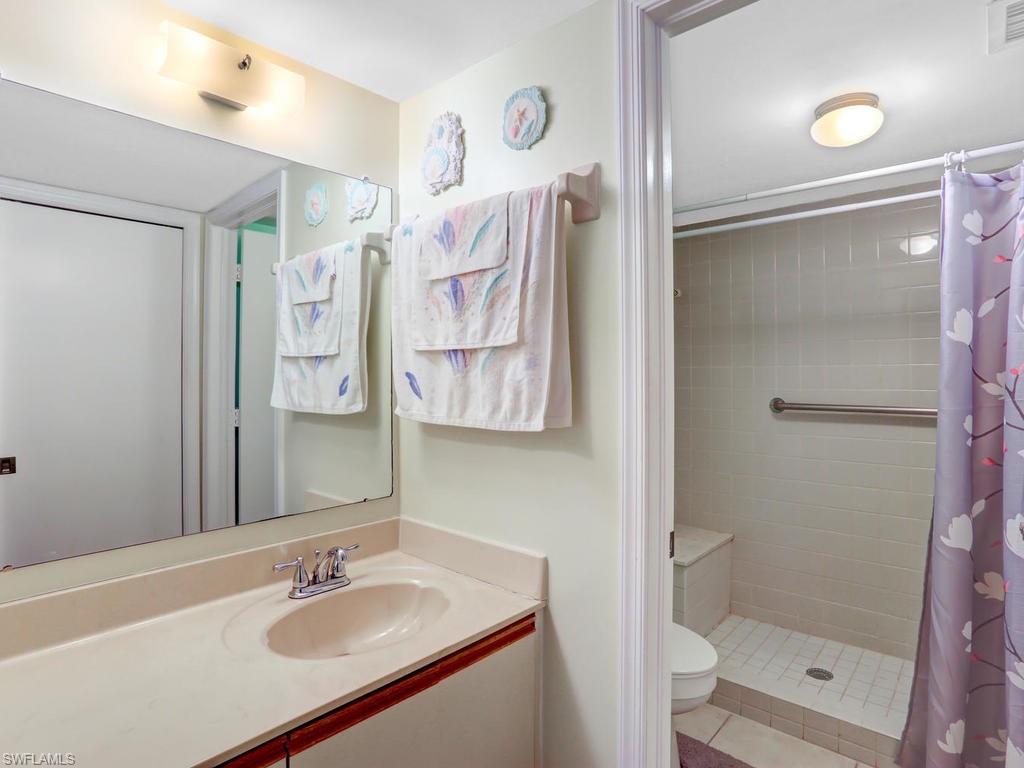 5675 Whitaker Road, Unit B102 Naples, FL 34112 - Photo 19 of 22 a bathroom with a sink shower and a mirror