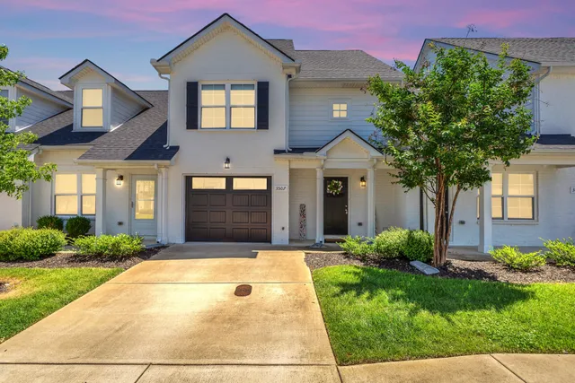 a front view of a house with a yard and potted plants