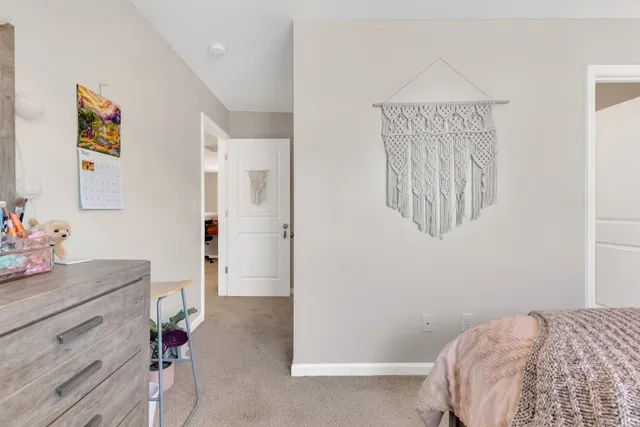 a bedroom with a bed and a mirror on the dresser