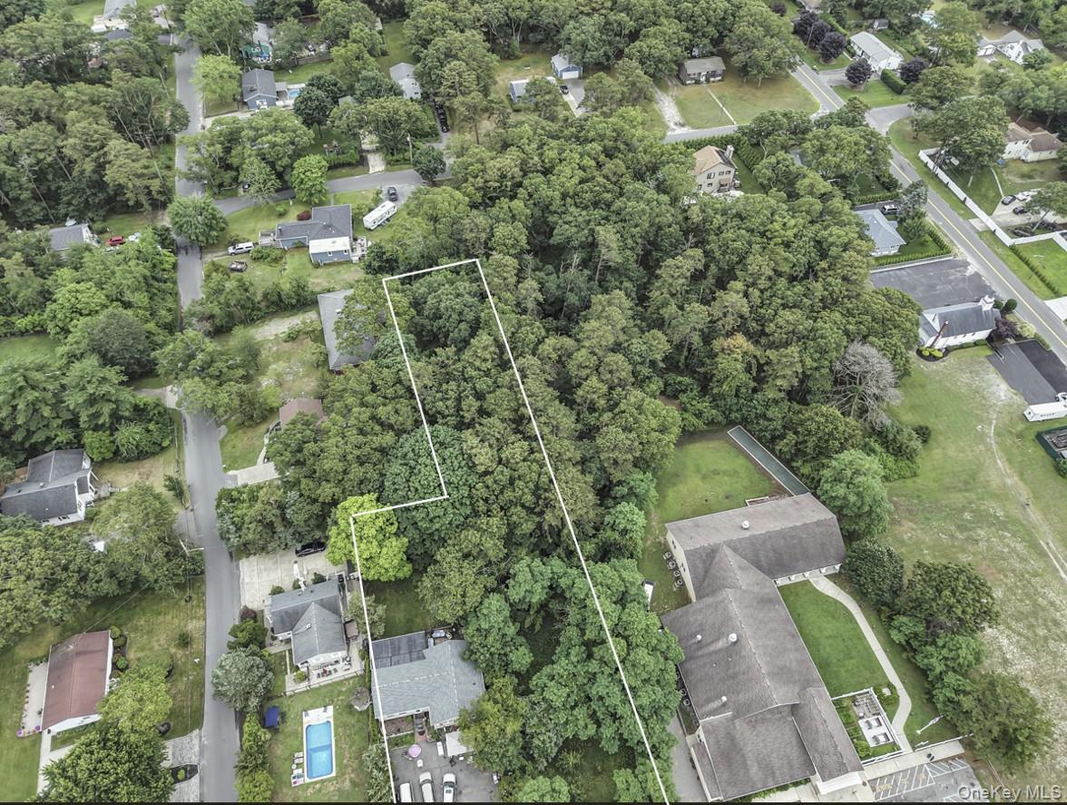 669 Flanders Road Flanders, NY 11901 - Photo 16 of 16 an aerial view of a house with a yard and large trees