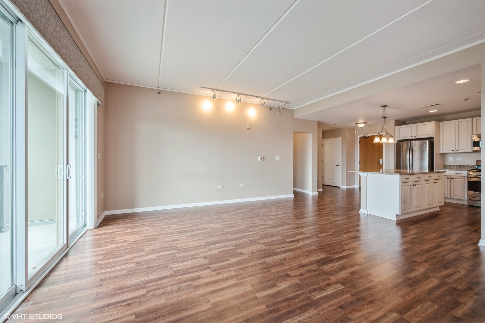 1199 East Port Clinton Road, Unit 610 Vernon Hills, IL 60061 - Photo 5 of 16 a view of a living room a kitchen with wooden floor and a kitchen