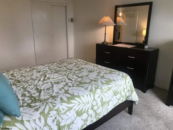 a bedroom with a bed and a mirror on dresser