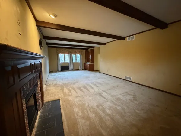 a view of empty room with wooden floor and fireplace